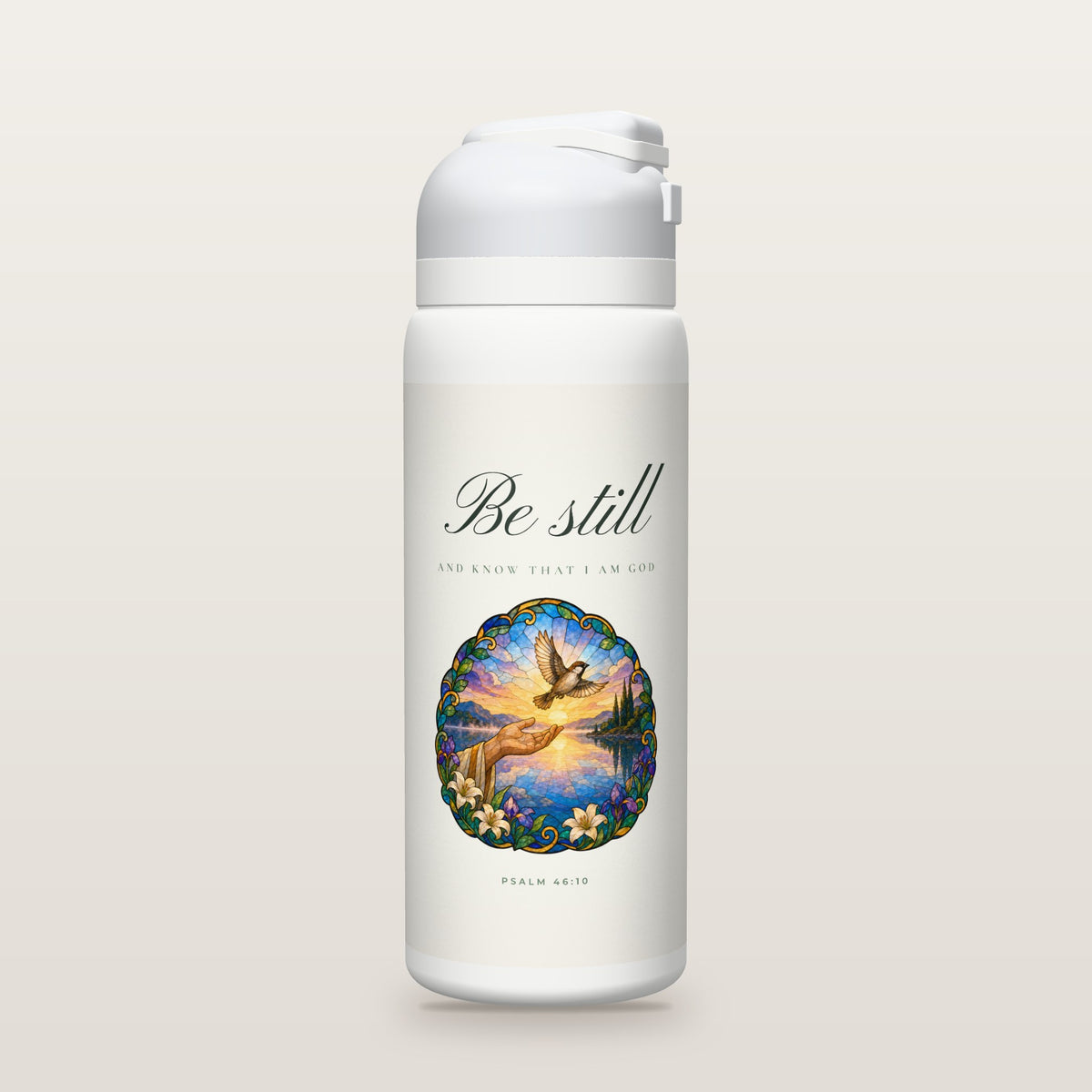 White Owala water bottle with a soft white printed band, the script words Be still above a stained-glass illustration of an open hand releasing a sparrow over a calm lake at dawn, Psalm 46:10.