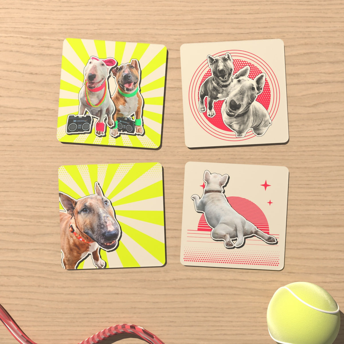 A set of four retro pet coasters with bull terriers on sunbursts, a badge and a sunset, next to a tennis ball and a red leash