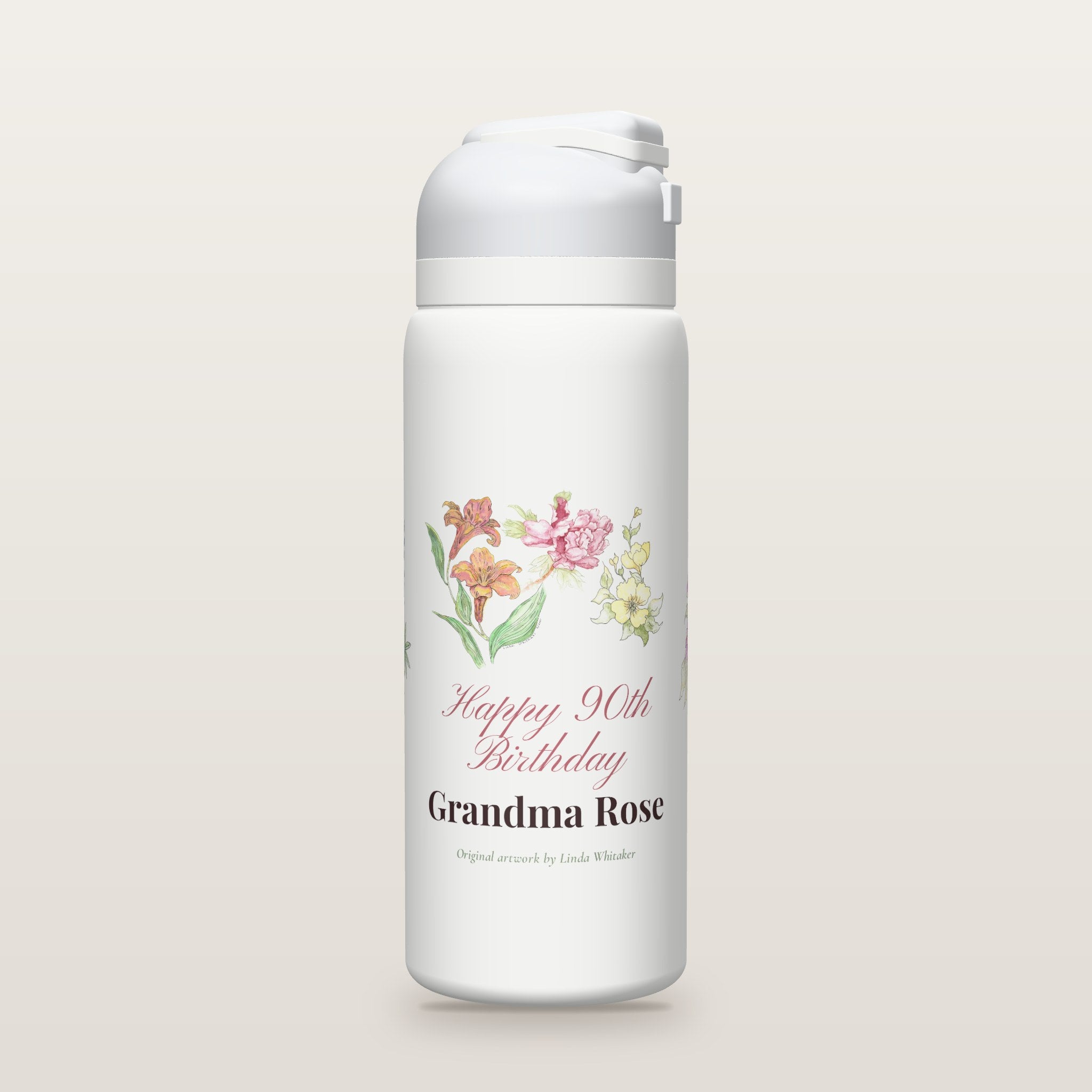 White Owala water bottle printed with watercolor lilies, a peony, yellow blossoms, purple asters and bluebonnets by Linda Whitaker, with Happy 90th Birthday Grandma Rose as a sample name and age.